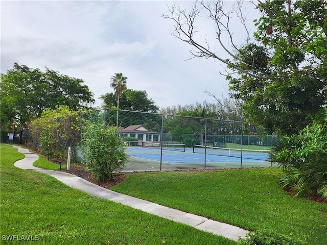 view of sport court with a lawn