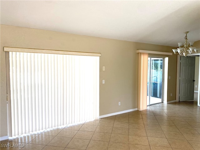 empty room featuring light tile patterned floors and an inviting chandelier