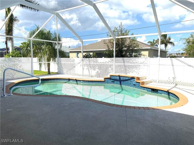 view of swimming pool featuring a lanai, a fenced in pool, a patio, and a fenced backyard