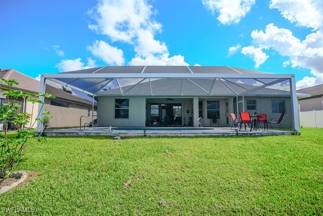 back of house featuring a patio, a yard, and glass enclosure