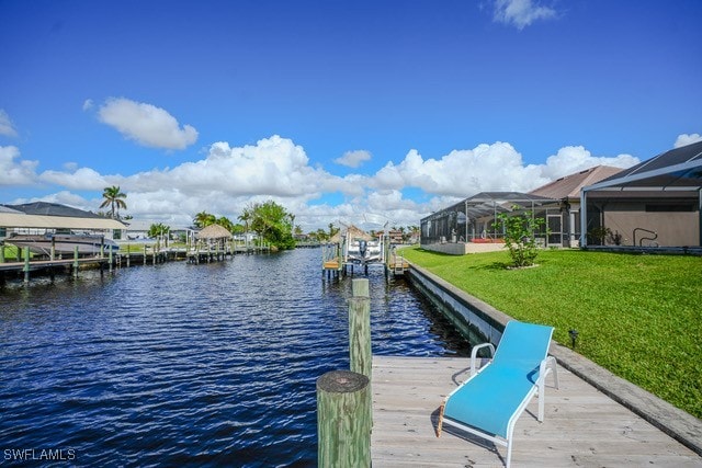 view of dock featuring a lawn, a lanai, and a water view