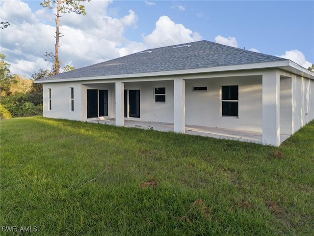 rear view of house with a yard and a patio