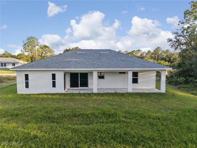 rear view of property featuring a lawn and a patio