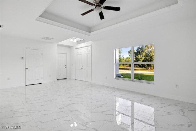 empty room with ceiling fan, crown molding, and a tray ceiling