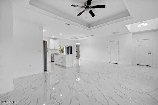 unfurnished living room featuring a raised ceiling and crown molding