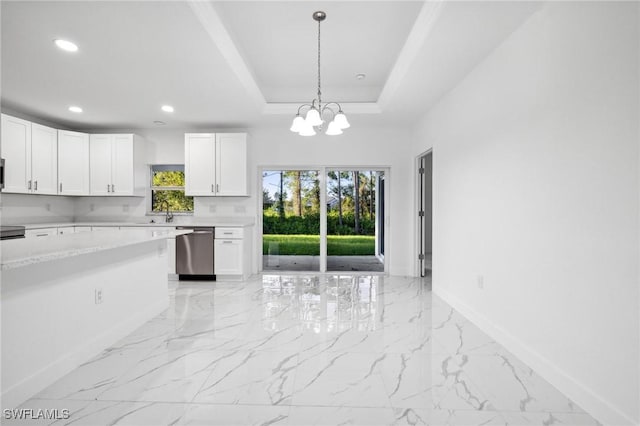 kitchen featuring appliances with stainless steel finishes, a raised ceiling, a chandelier, pendant lighting, and white cabinets