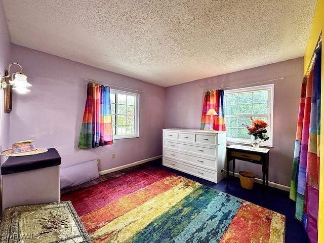 bedroom featuring a textured ceiling and multiple windows