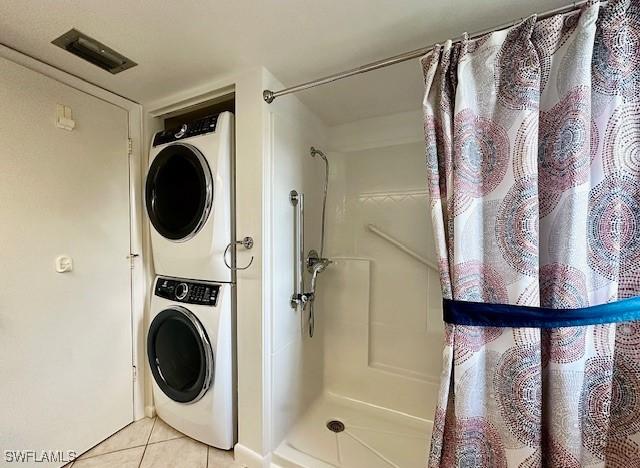 washroom featuring light tile patterned floors and stacked washer / dryer