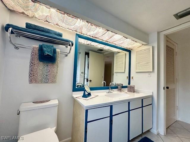 bathroom featuring tile patterned flooring, vanity, and toilet