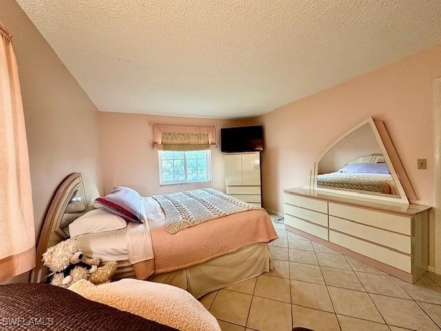 tiled bedroom with a textured ceiling