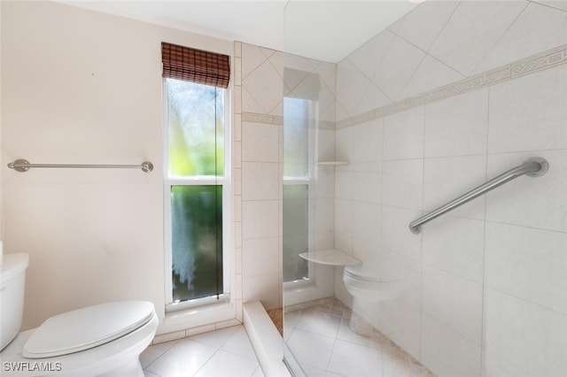 355 Palm Dr Unit 1, Naples, FL 34112 - bathroom featuring toilet, a tile shower, tile patterned flooring, and tile walls