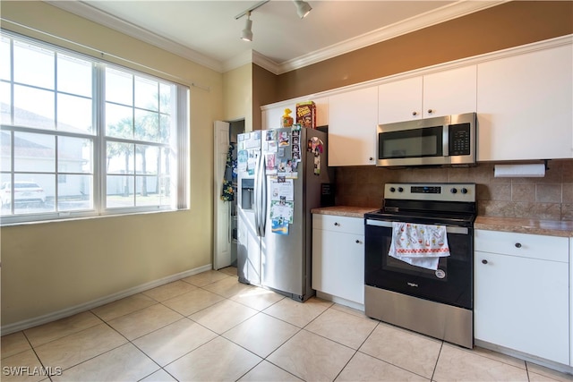 kitchen with decorative backsplash, white cabinets, stainless steel appliances, and light tile patterned floors