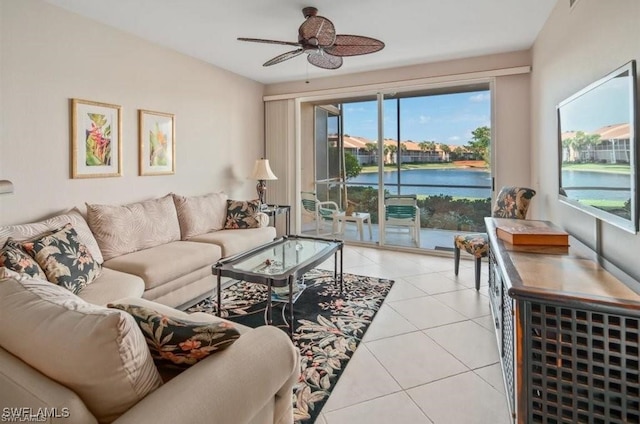 tiled living room featuring ceiling fan and a water view