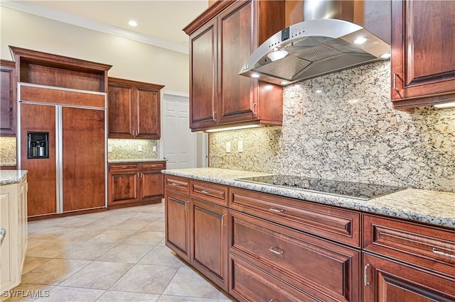 kitchen featuring extractor fan, black electric stovetop, paneled built in fridge, and backsplash