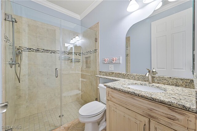 bathroom with tile patterned floors, toilet, a shower with shower door, ornamental molding, and vanity