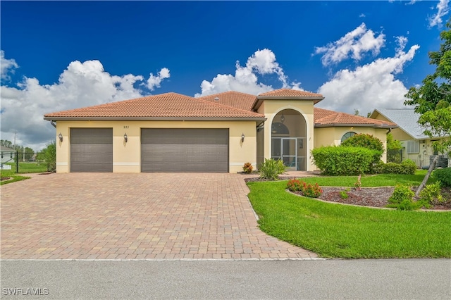 mediterranean / spanish-style home with a front yard and a garage