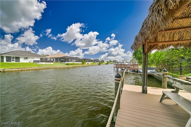 view of dock with a water view and a lawn