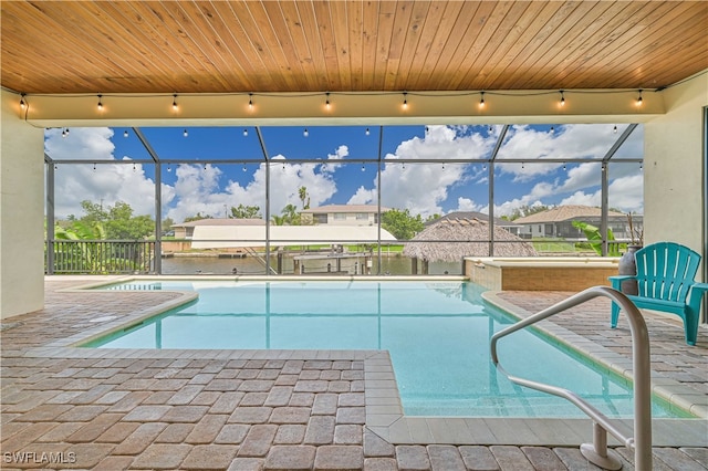 view of swimming pool featuring a patio and glass enclosure