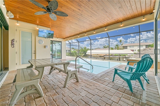 view of swimming pool featuring a lanai, a patio, and ceiling fan