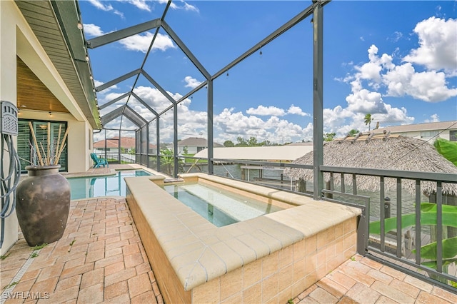 view of swimming pool featuring an in ground hot tub, a patio, and a lanai