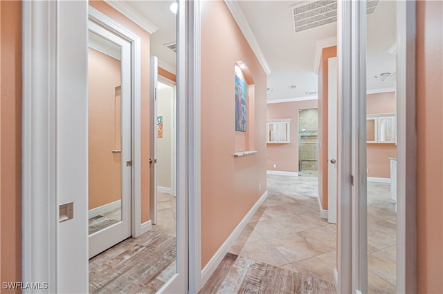 hall with crown molding and light tile patterned flooring