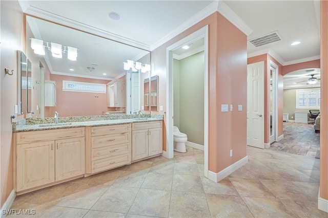 bathroom with vanity, toilet, crown molding, and ceiling fan