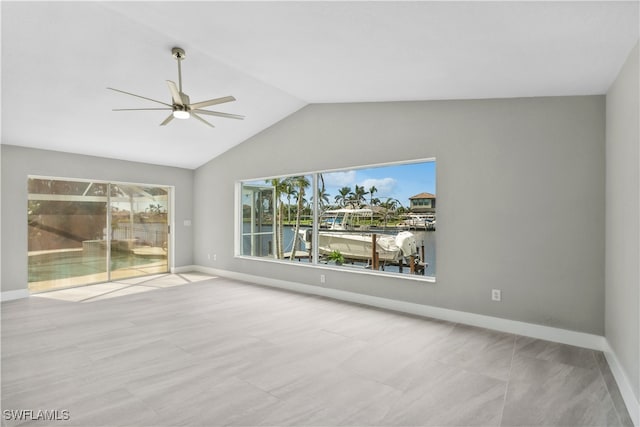 unfurnished living room with ceiling fan, a water view, and lofted ceiling