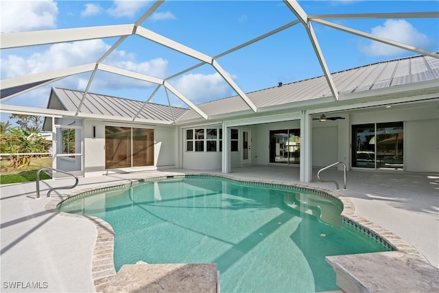 view of swimming pool featuring a patio area, ceiling fan, and glass enclosure