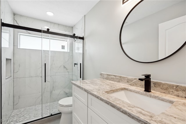 bathroom featuring vanity, toilet, and a shower with shower door