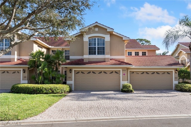 20301 E Calice Ct Unit 2002, Estero, FL 33928 - view of front of house with a tile roof, stucco siding, a front lawn, and decorative driveway