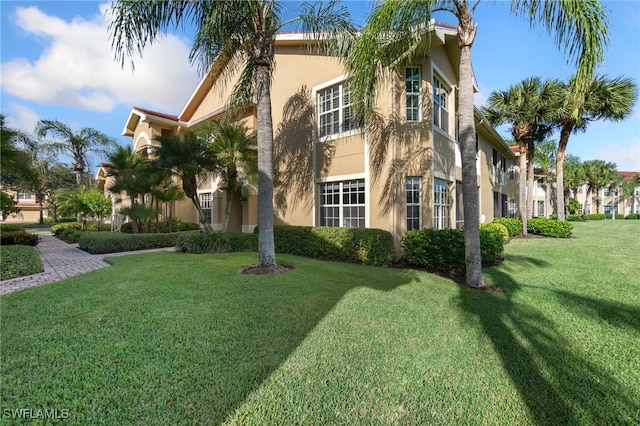 20301 E Calice Ct Unit 2002, Estero, FL 33928 - view of side of property with a yard and stucco siding