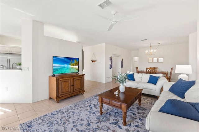 tiled living room featuring ceiling fan with notable chandelier