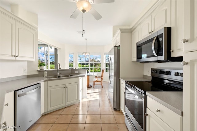 kitchen featuring light tile patterned flooring, white cabinetry, sink, and appliances with stainless steel finishes