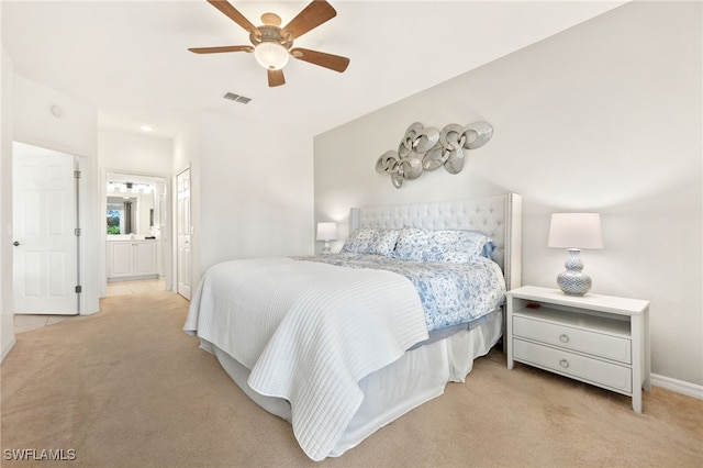 carpeted bedroom featuring ceiling fan and ensuite bath