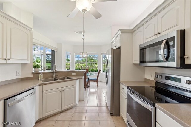 20301 E Calice Ct Unit 2002, Estero, FL 33928 - kitchen with light tile patterned flooring, visible vents, a sink, a peninsula, and appliances with stainless steel finishes