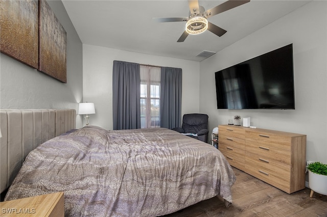 bedroom with hardwood / wood-style floors, radiator, and ceiling fan