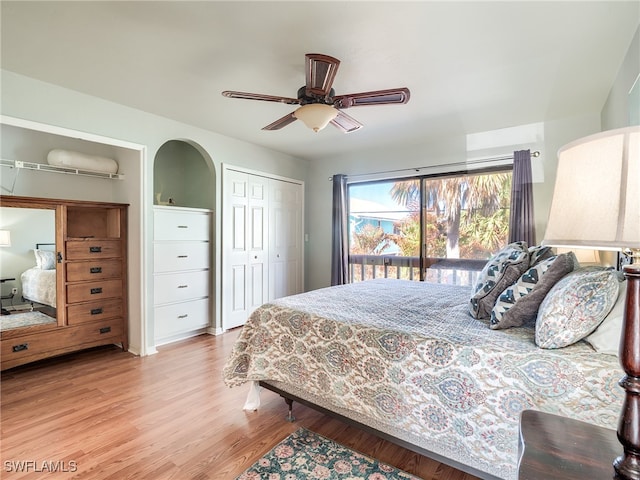 bedroom with access to exterior, light hardwood / wood-style floors, ceiling fan, and a closet