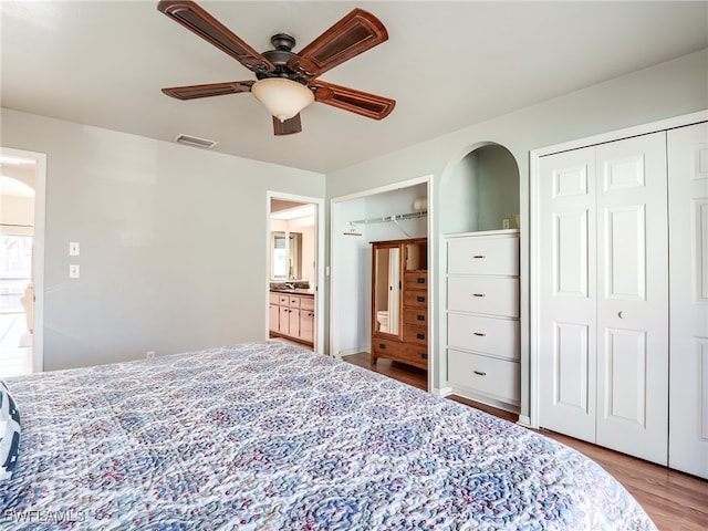 bedroom with ensuite bathroom, ceiling fan, and light hardwood / wood-style flooring