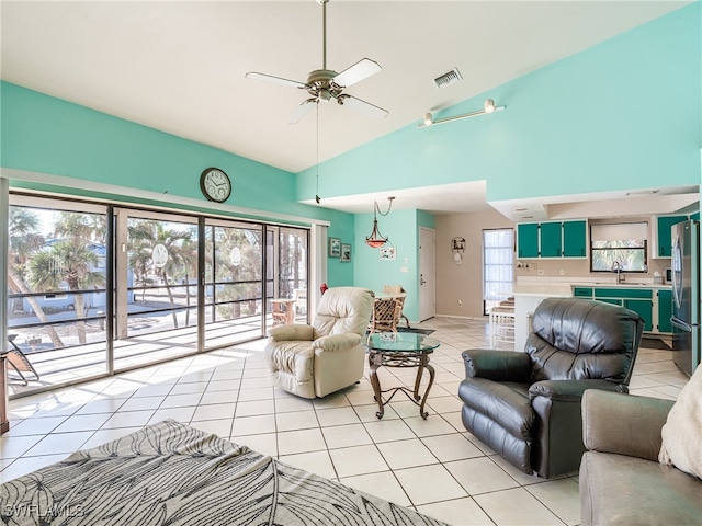 tiled living room featuring high vaulted ceiling, a wealth of natural light, sink, and ceiling fan