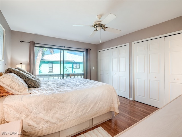 bedroom with access to exterior, wood-type flooring, ceiling fan, and two closets