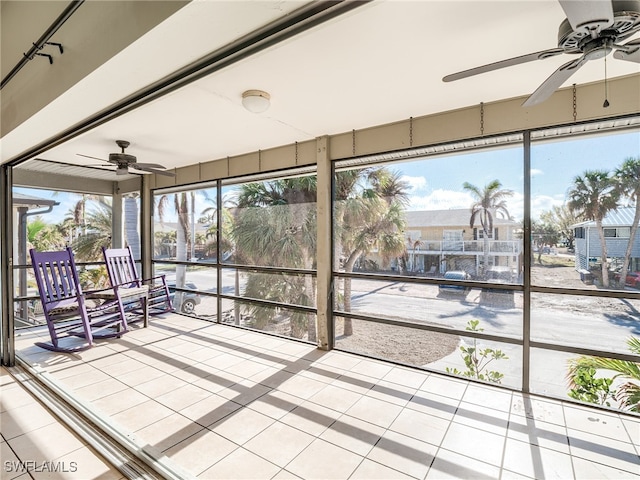 unfurnished sunroom with ceiling fan