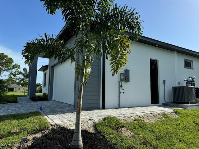 view of property exterior featuring central AC and a garage