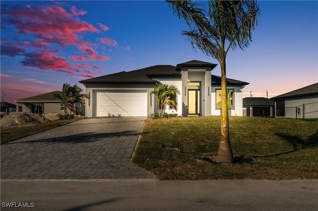 view of front of home featuring a garage and a lawn