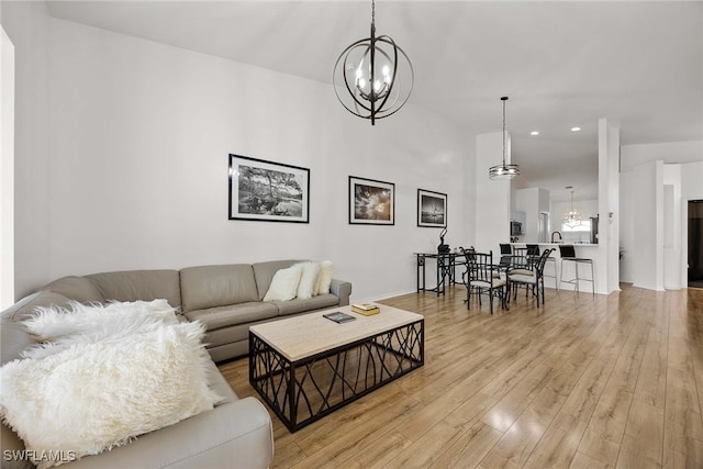 living room featuring light hardwood / wood-style floors and an inviting chandelier