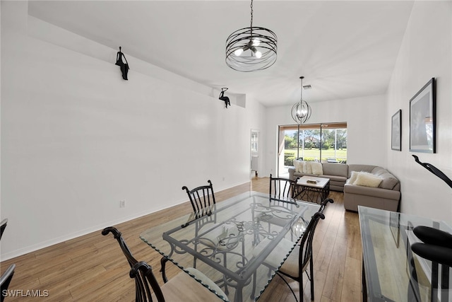 dining space featuring hardwood / wood-style floors and a chandelier