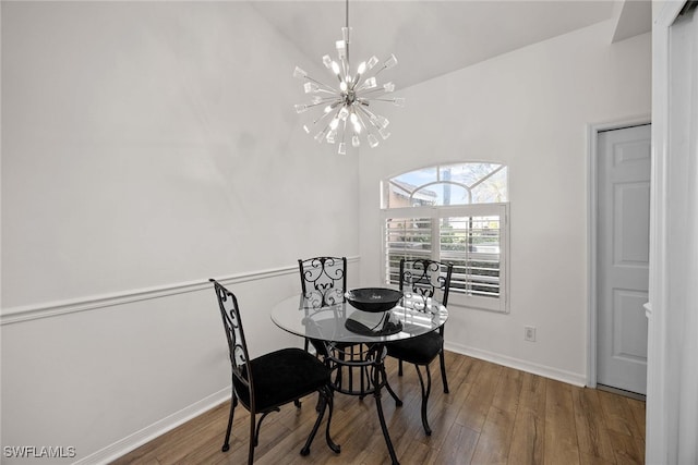 dining space with high vaulted ceiling, a chandelier, and hardwood / wood-style flooring