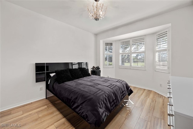 bedroom featuring light hardwood / wood-style floors and a notable chandelier