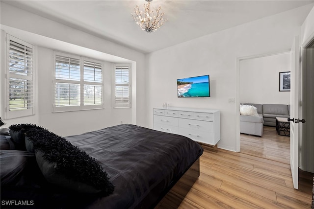 bedroom with a chandelier and light hardwood / wood-style flooring