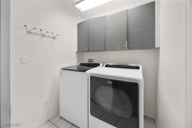 laundry room featuring light tile patterned flooring, cabinets, and washing machine and dryer