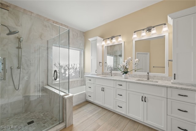 bathroom featuring vanity, wood-type flooring, and shower with separate bathtub